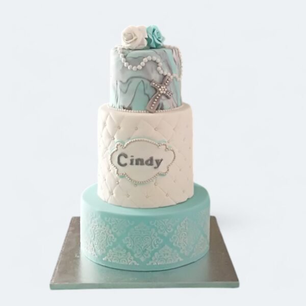 Gâteau de communion ou baptême bleu et blanc avec perles, croix et chapelet, réalisé par Queen Cake à Nice.
